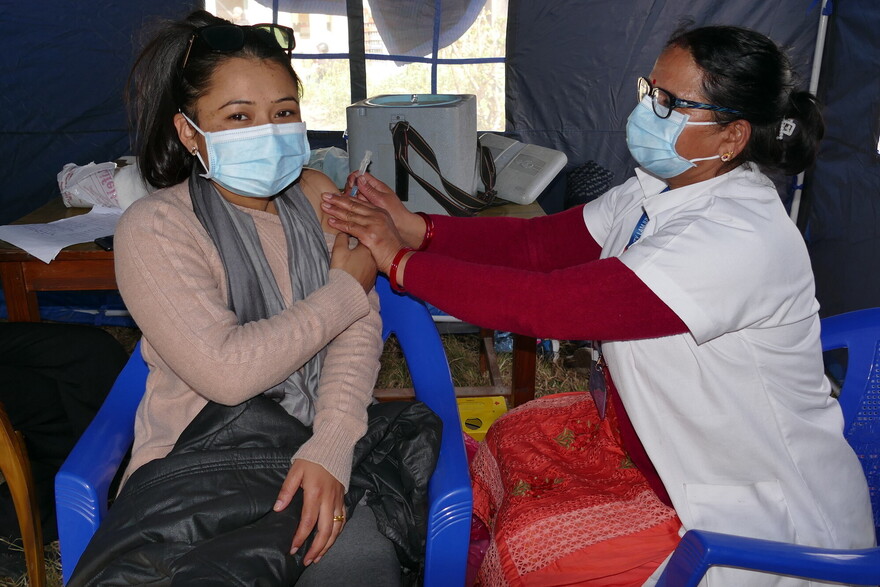 Eine Helferin impft eine Frau in Nepal gegen Covid-19 Eine Helferin impft eine Frau in Nepal gegen Covid-19