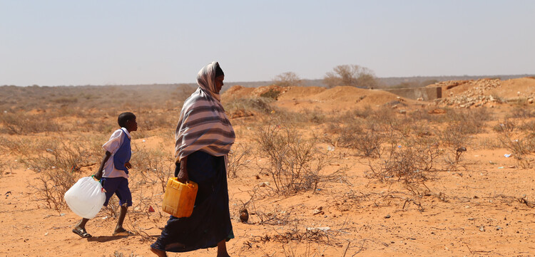 Eine Frau und ein Kind aus Afrika beim Wasserholen in der Wüste Eine Frau und ein Kind aus Afrika beim Wasserholen in der Wüste